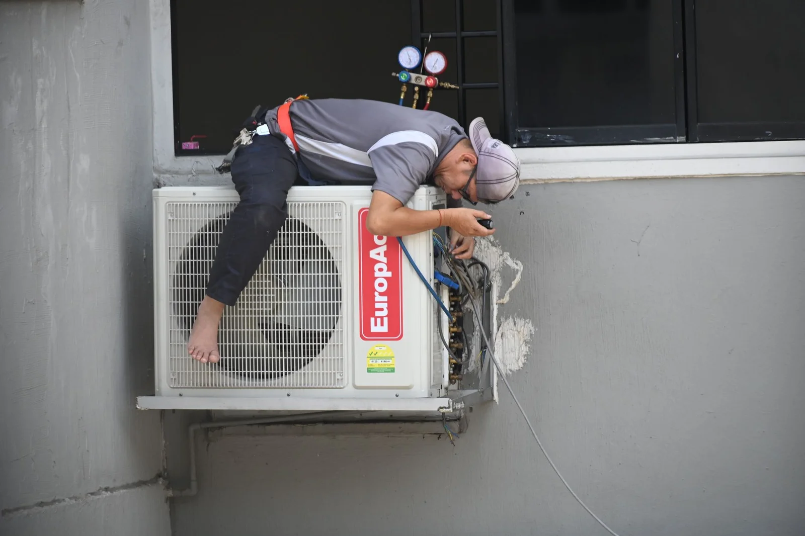 Technician inspecting an outdoor condenser during a home sale evaluation